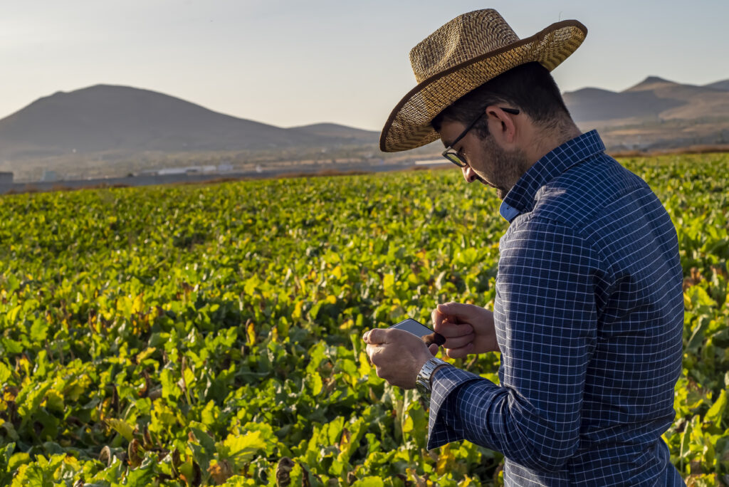 caucasian farmer in a hat using modern technology in agriculture. smart farming caucasian farmer in a hat using modern technology in agriculture. smart farming